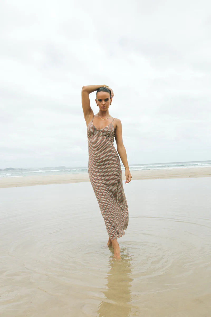 Charlie Holiday Lulu maxi dress shown on the beach. A striped patterned dress
