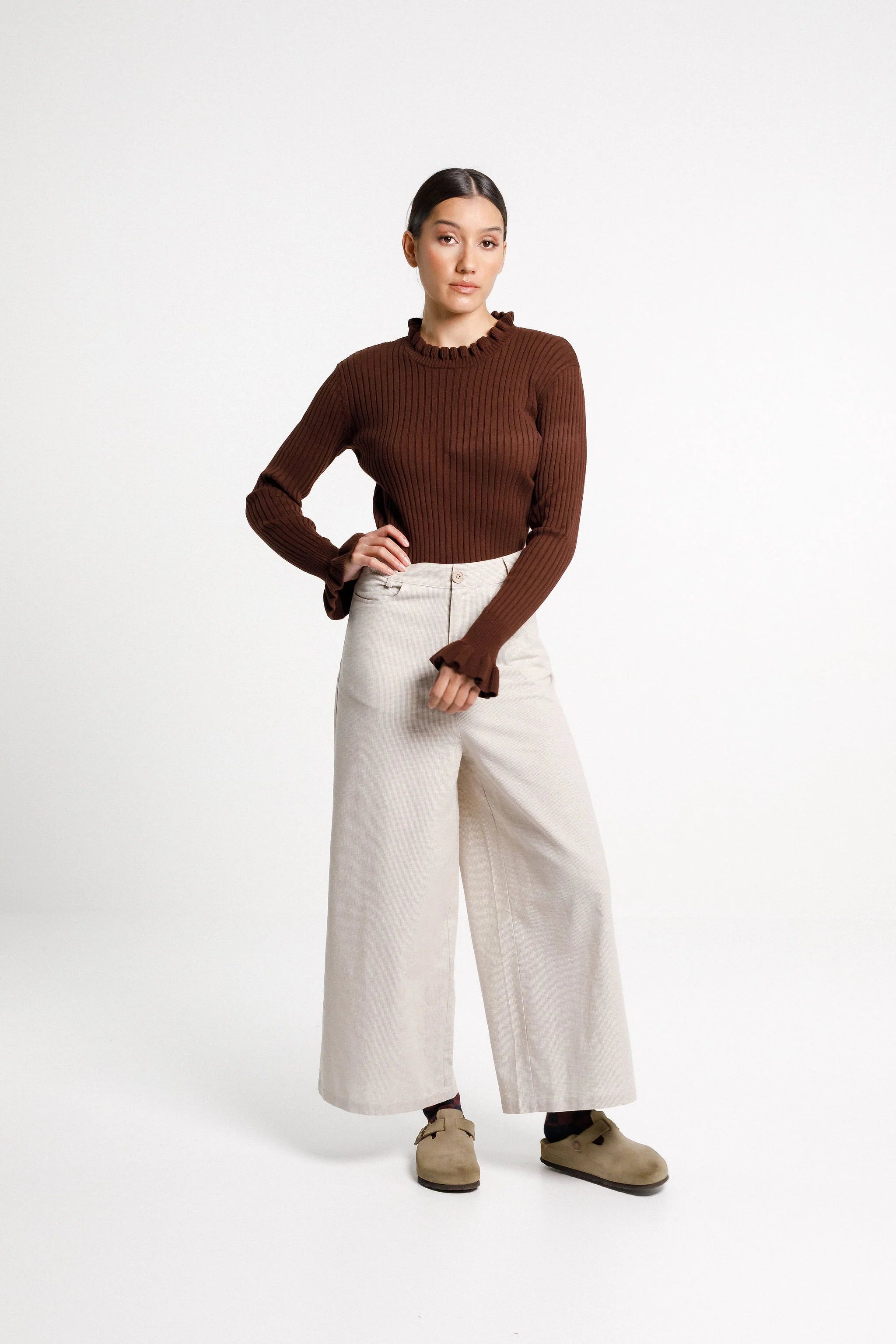 Tailored pant is mid-rise, wide leg with front pockets and squared back pockets. Cut in a cotton/ linen blend in a check fabric