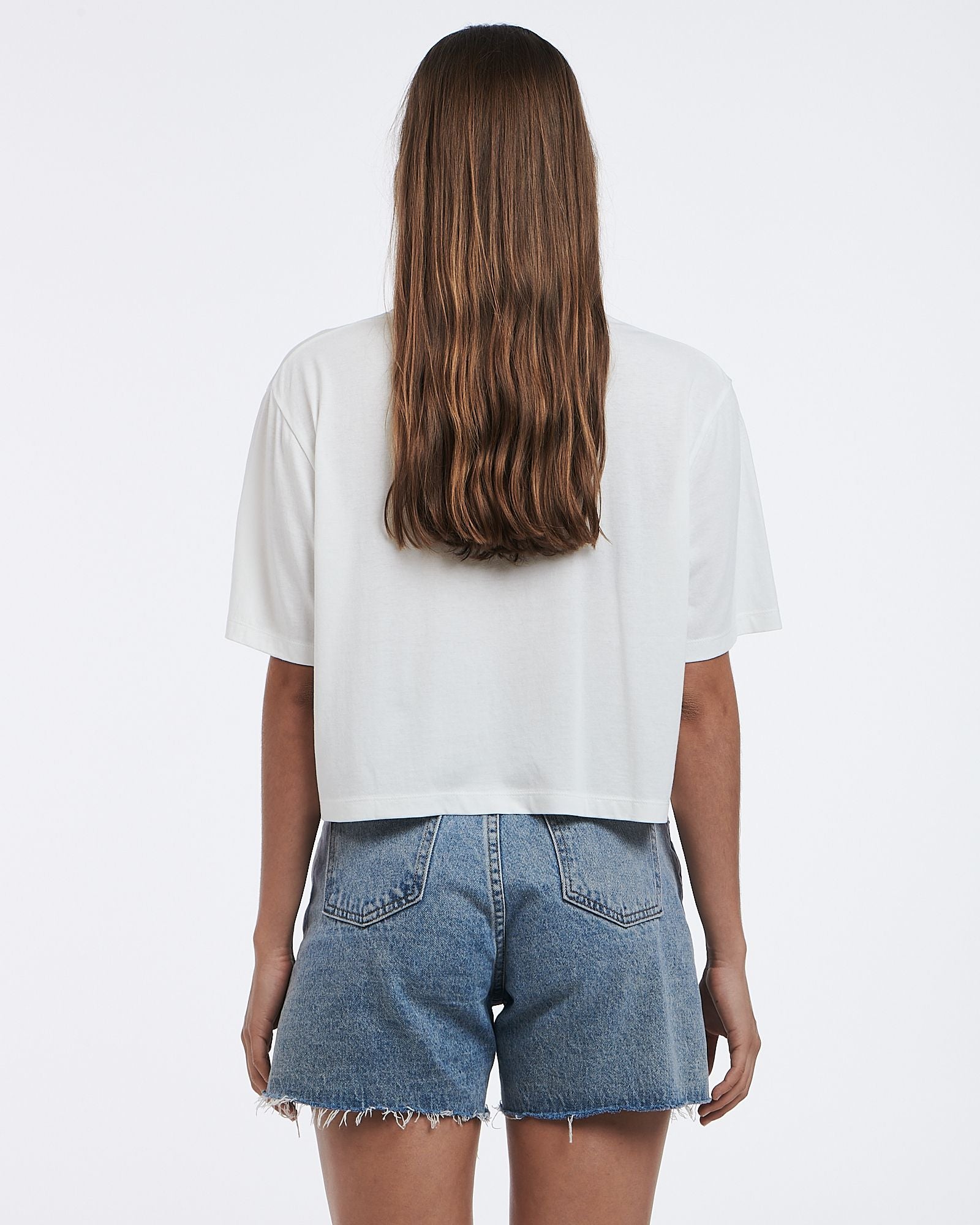 This cropped white tee features a subtle graphic and boxy shape.