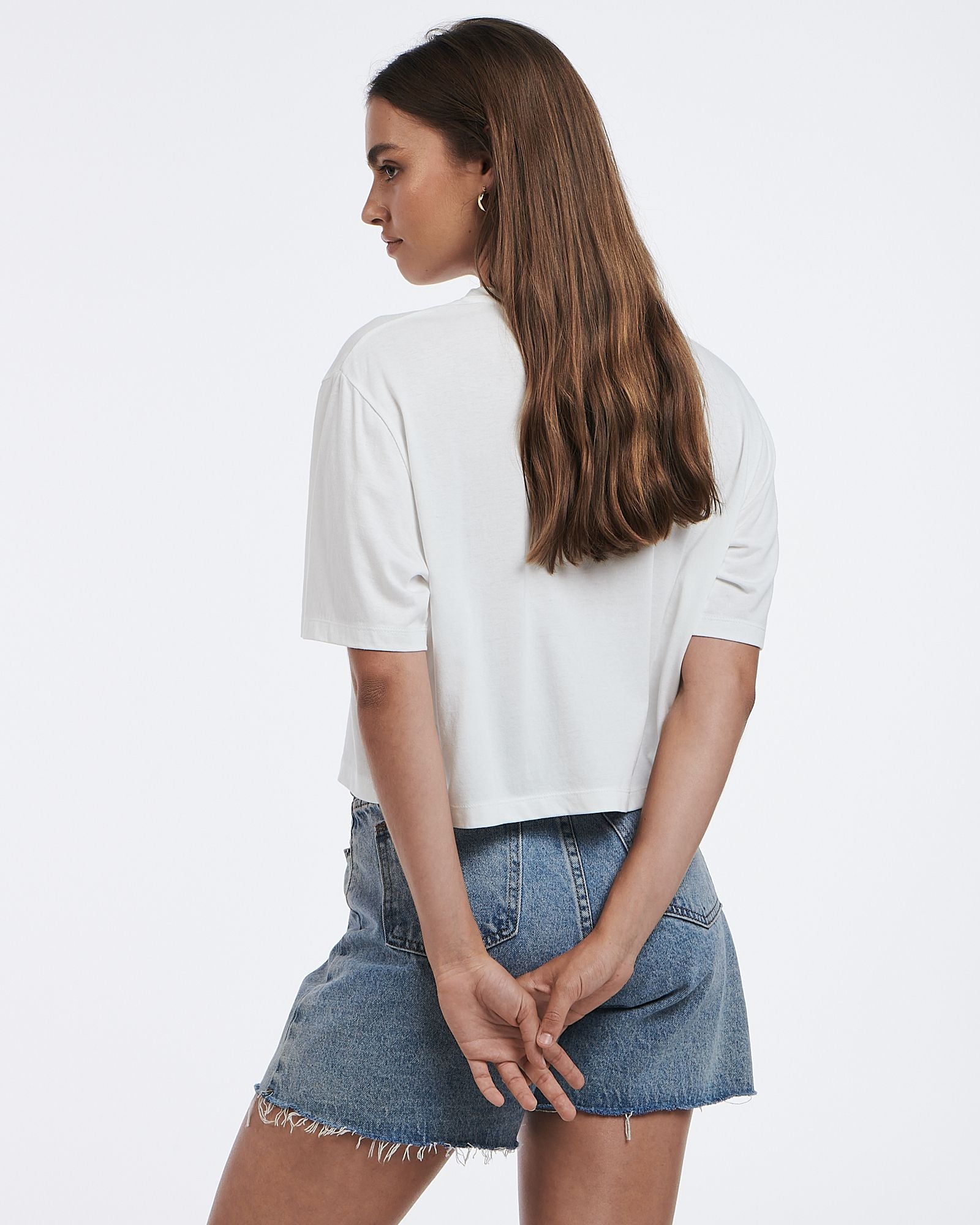 This cropped white tee features a subtle graphic and boxy shape.