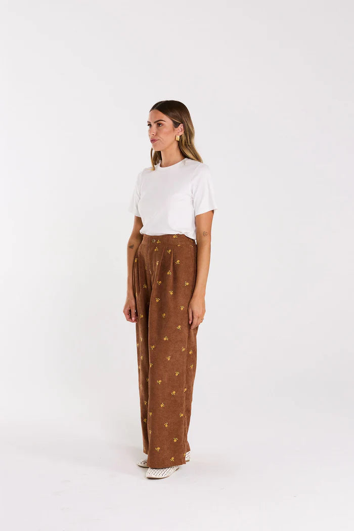 Front pleats,elasticated back. Pockets up front, welt pocket behind, all in a floral embroidered cord. cotton