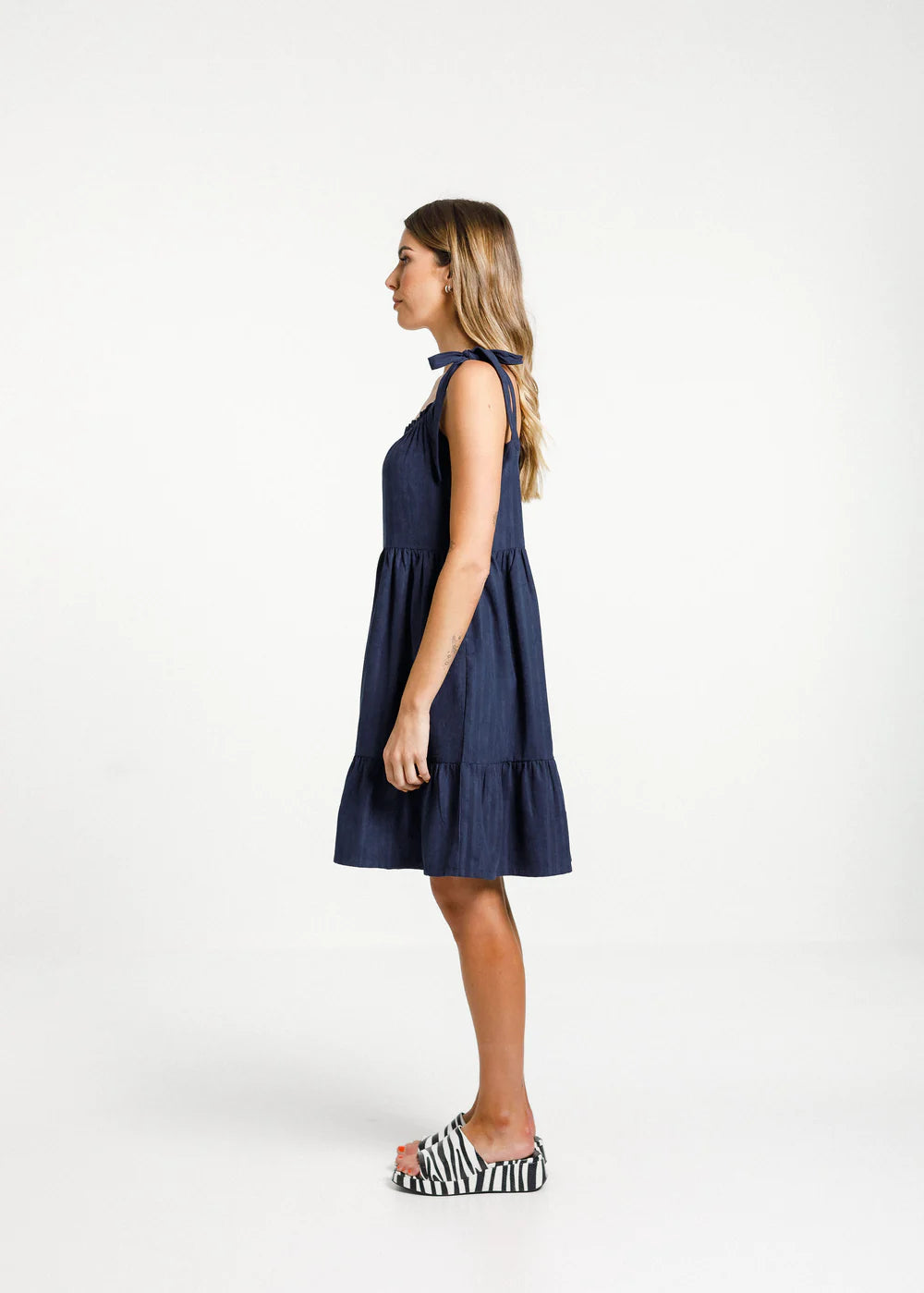 Short navy blue dress from Thing Thing with square cut front, gathered layers and deep pockets