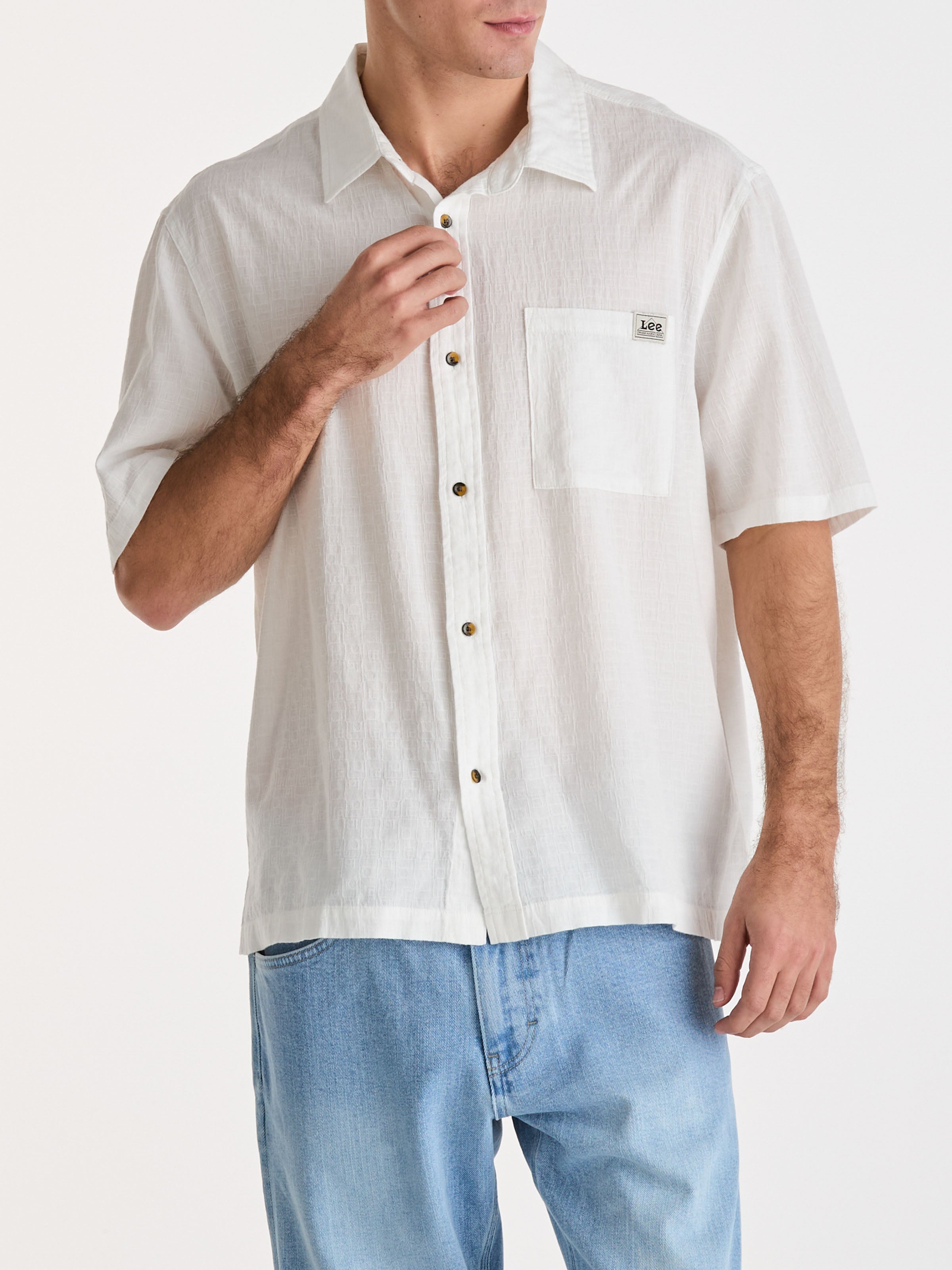Man wearing a white short-sleeve button-up shirt with a pocket on a white background