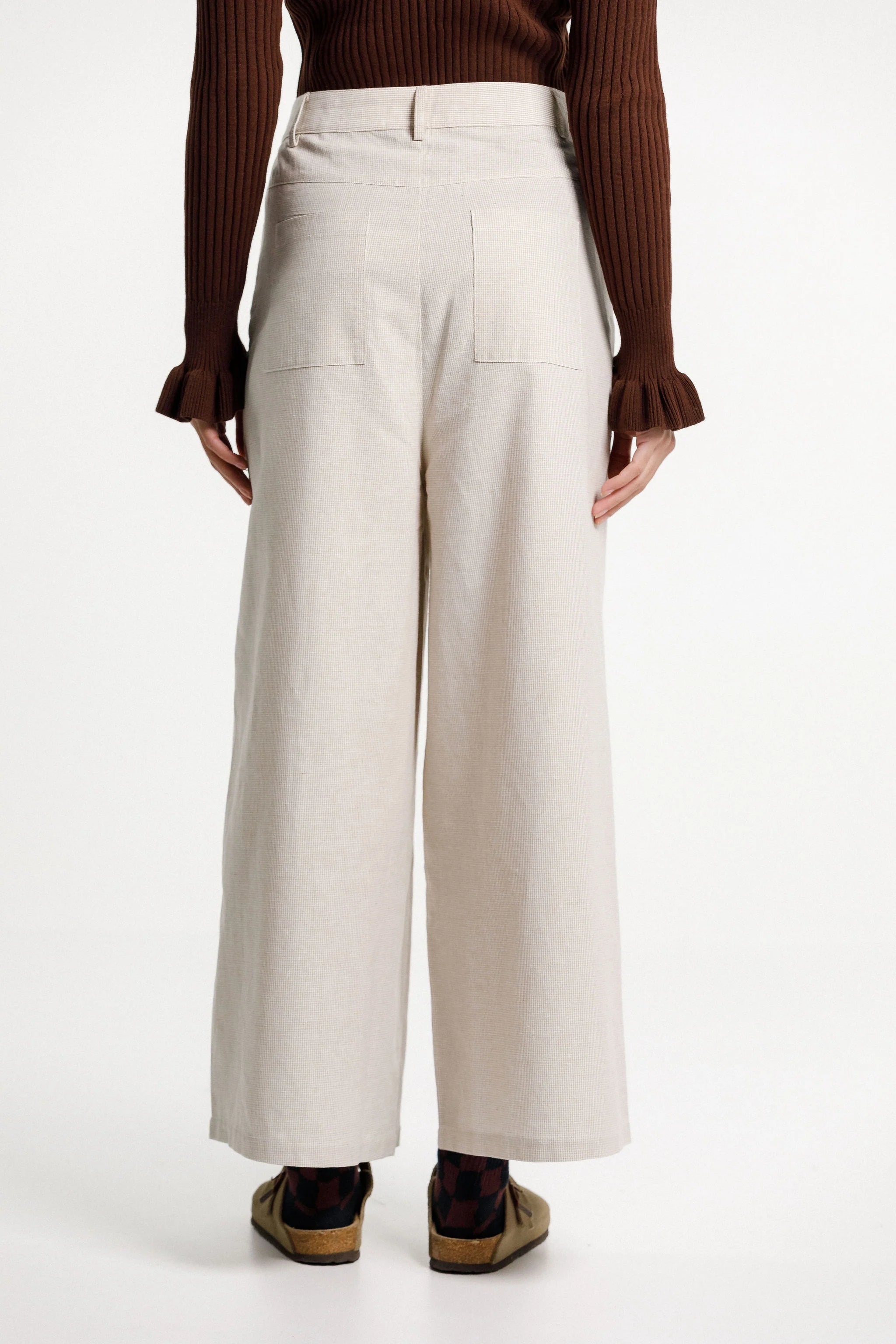 Tailored pant is mid-rise, wide leg with front pockets and squared back pockets. Cut in a cotton/ linen blend in a check fabric